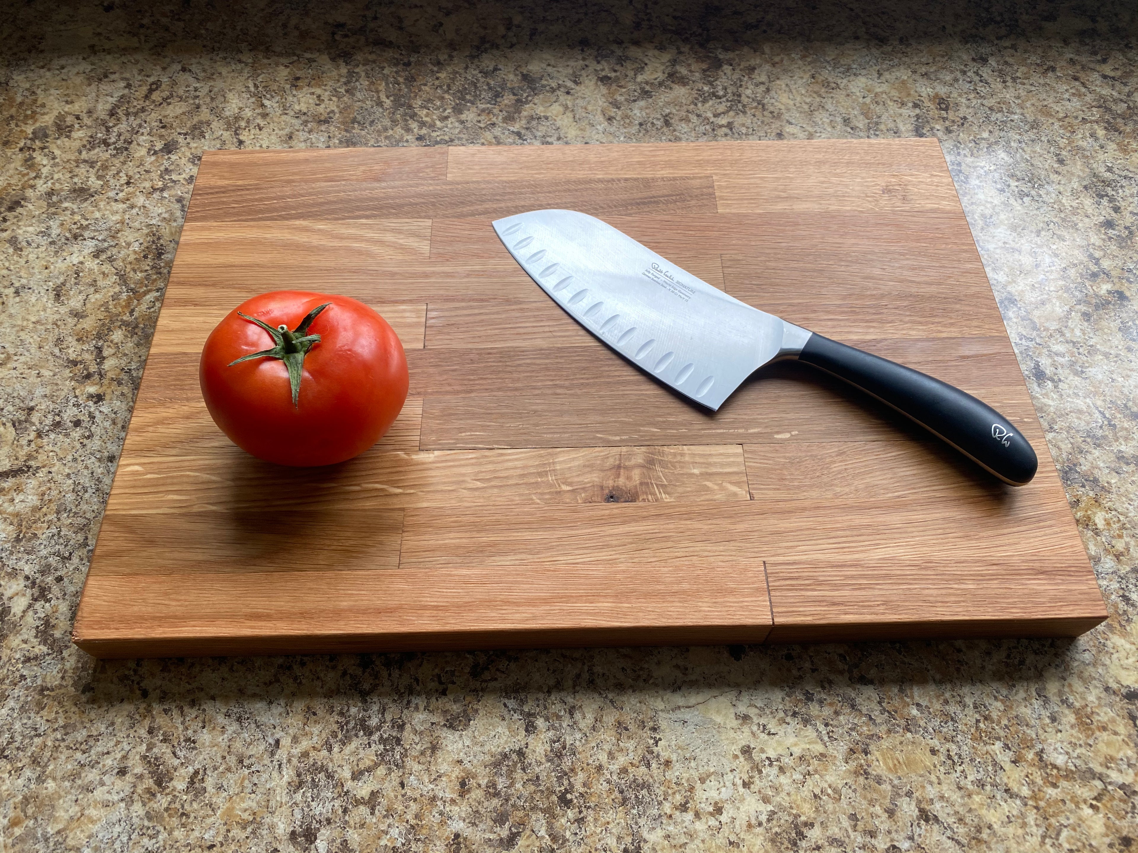 Tomato and knife on a wooden cutting board