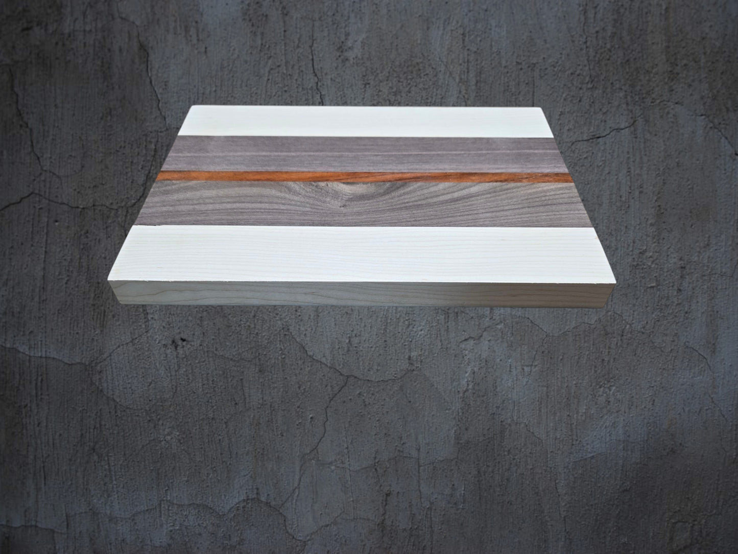 Ash walnut and pink ivory cheese board used for serving cheese and charcuterie