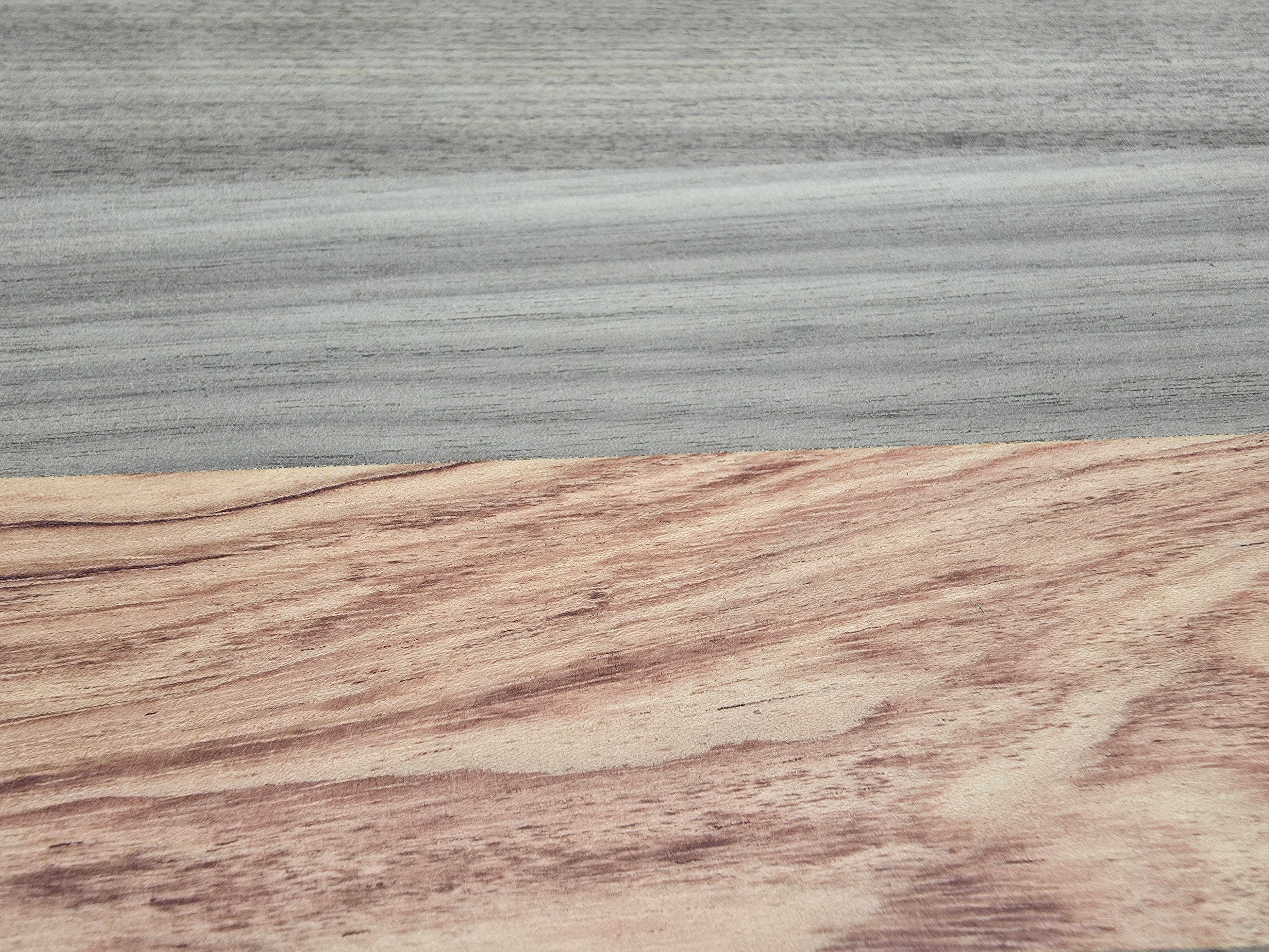 Close up of walnut and pink ivory wood grain on luxury cheese board