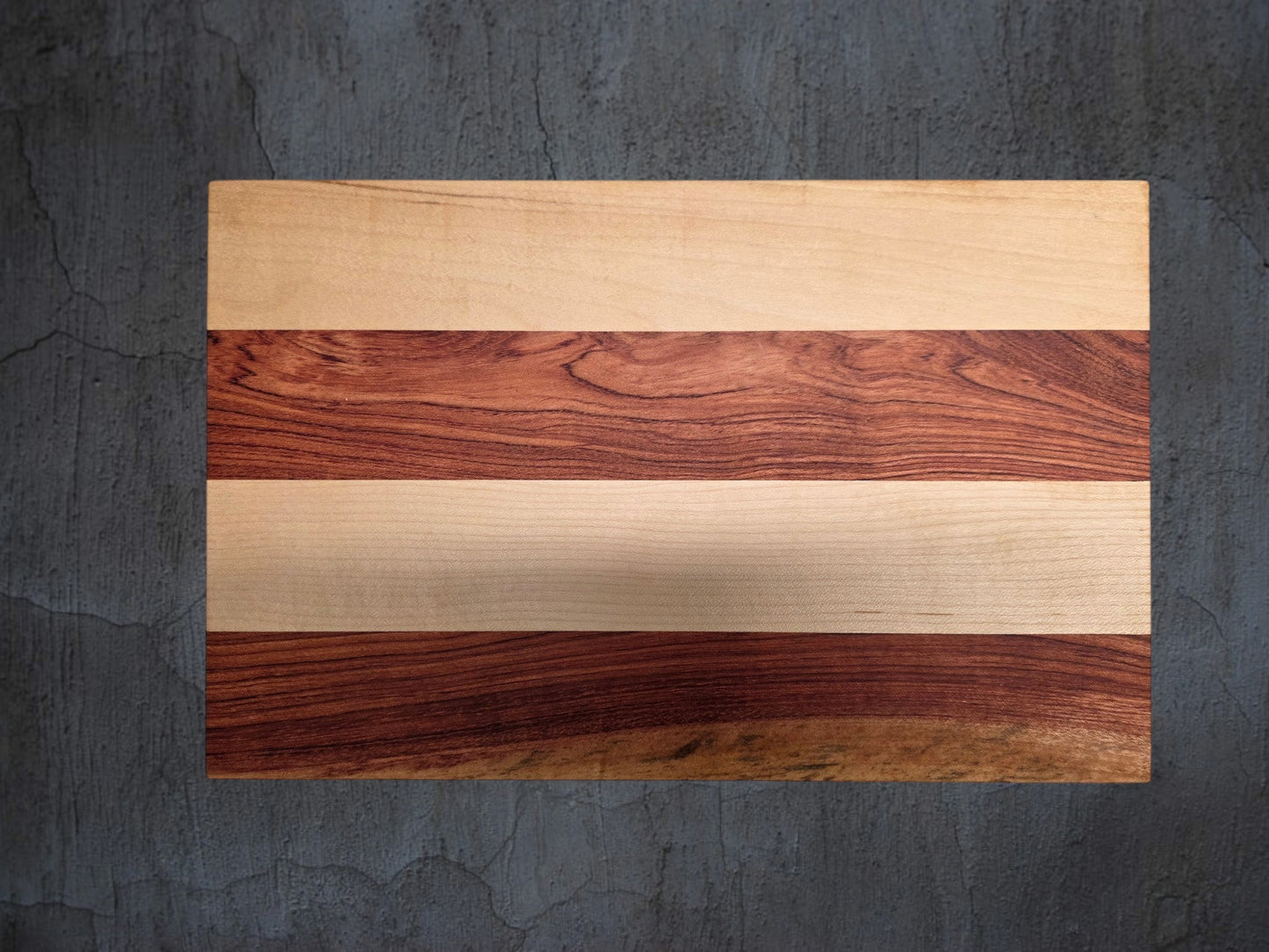 Close up of pink ivory and ash wood grain on handmade cheese board